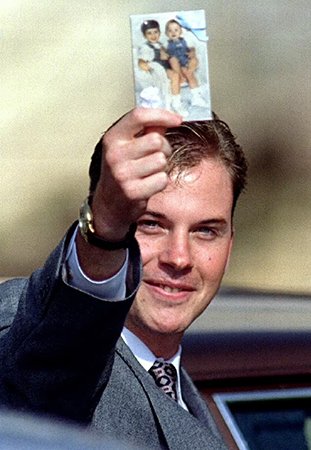 David Smith holds up a photo of Michael and Alex after his ex-wife was sentenced to two life terms for murder
